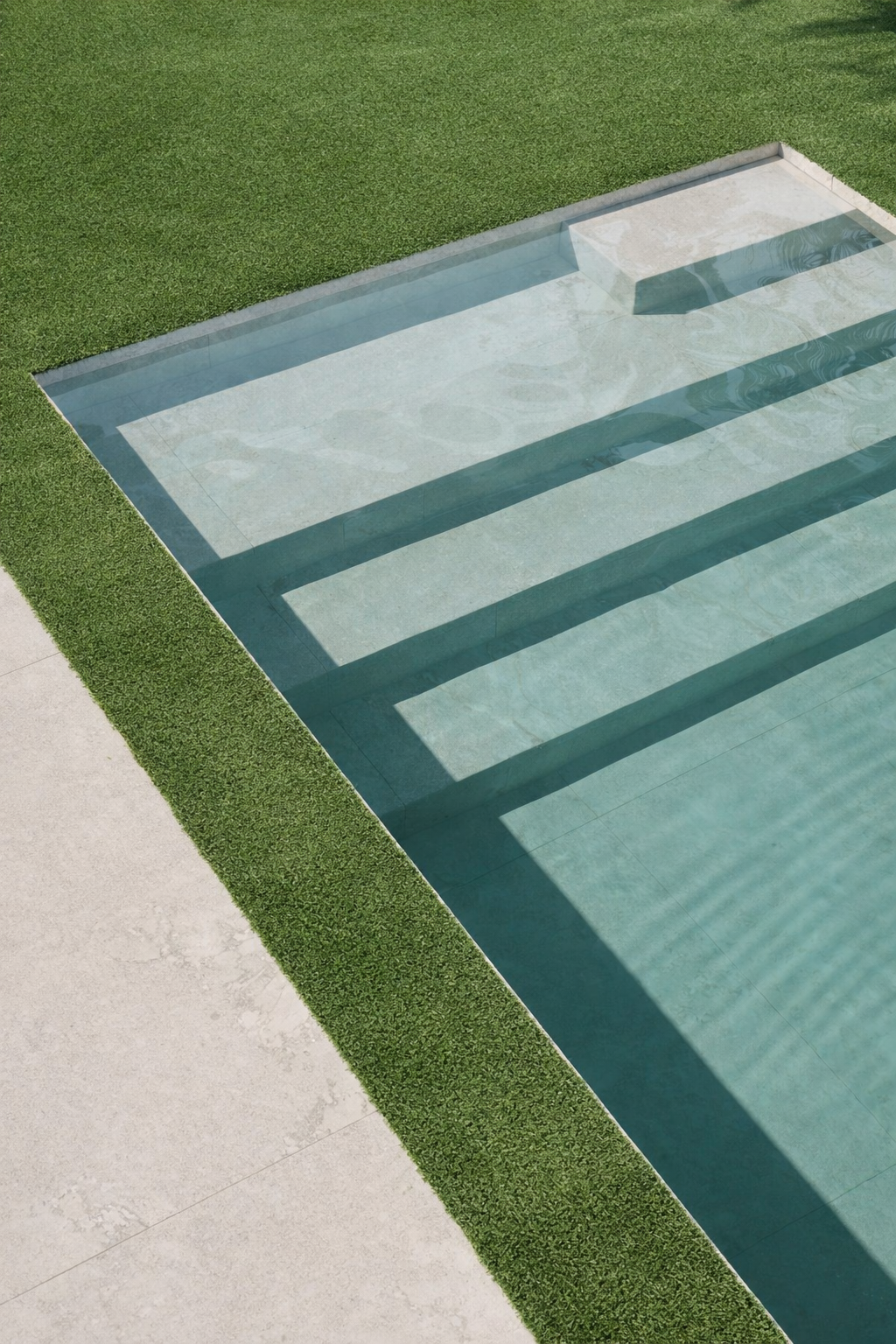 Piscina de diseño contemporáneo con entorno ajardinado